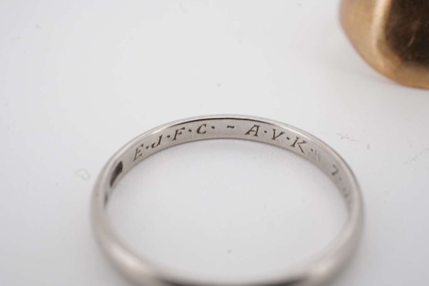 A 1940's platinum wedding band, with engraved inscription, size M, 2.3 grams together with a 9ct signet ring and a yellow metal wedding band.